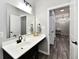 Modern bathroom featuring a sleek vanity and a large mirror, with a glimpse into the hallway beyond at 21536 Gisborne Dr, Noblesville, IN 46062
