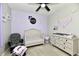 Delightful bedroom featuring lavender walls, a crib, and changing table with a ceiling fan at 21536 Gisborne Dr, Noblesville, IN 46062