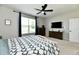 Bright bedroom with ceiling fan, TV, dresser, and large window at 21536 Gisborne Dr, Noblesville, IN 46062