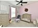 Cozy bedroom featuring pink walls, neutral furnishings and a ceiling fan at 21536 Gisborne Dr, Noblesville, IN 46062