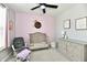 Inviting bedroom with a crib, rocking chair, and neutral-toned walls, illuminated by a ceiling fan at 21536 Gisborne Dr, Noblesville, IN 46062