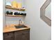 Practical laundry room with wooden shelves, stainless steel sink and gray cabinets at 21536 Gisborne Dr, Noblesville, IN 46062