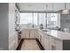 Modern kitchen with white cabinets, quartz countertops, stainless appliances, and a window with a city view at 225 N New Jersey St # 52, Indianapolis, IN 46204
