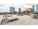 Spacious rooftop deck with lounge chairs and outdoor seating, offering city views of downtown buildings at 225 N New Jersey St # 52, Indianapolis, IN 46204