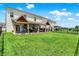 Spacious backyard featuring a covered patio, lush lawn, and a black metal fence at 2282 Creekland Dr, Columbus, IN 47201