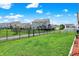 Well-maintained backyard with lush grass, a black fence, and neighboring homes at 2282 Creekland Dr, Columbus, IN 47201
