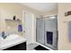 Well-lit bathroom featuring a shower with sliding glass doors, vanity, and decorative shelving for functional elegance at 2282 Creekland Dr, Columbus, IN 47201