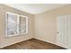 This bedroom features wood floors, neutral paint, a large window with blinds, and a white door at 2282 Creekland Dr, Columbus, IN 47201