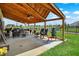 Expansive covered patio with multiple seating areas, grills, and a view of the backyard at 2282 Creekland Dr, Columbus, IN 47201