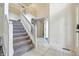 Bright foyer boasts tile floors, an open staircase with white railing, and a glimpse of the upper level at 2463 Kettering Way, Indianapolis, IN 46214