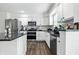 Updated kitchen features stainless appliances, granite countertops, white cabinets and vinyl flooring at 2463 Kettering Way, Indianapolis, IN 46214