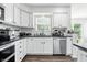 Bright and functional kitchen with stainless steel appliances, white cabinetry, dark countertops, and updated fixtures at 2463 Kettering Way, Indianapolis, IN 46214