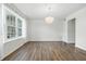 A bright, open living room featuring hardwood floors, a chandelier, and a large window with plenty of natural light at 2463 Kettering Way, Indianapolis, IN 46214