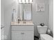 Bathroom with vanity with solid surface counters, framed mirror, decorative lighting, toilet and wainscoting at 2499 Blue Ridge Dr, Greenwood, IN 46143