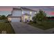 Charming two-story home with white siding, brick accents, and a well-manicured front yard at dusk at 2499 Blue Ridge Dr, Greenwood, IN 46143