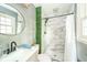 Renovated bathroom featuring a new vanity, stylish round mirror, and glass-enclosed shower at 2613 W Queensbury Rd, Muncie, IN 47304