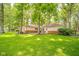 Well-maintained home exterior, situated in a lush, green backyard with mature trees at 2613 W Queensbury Rd, Muncie, IN 47304