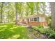 Single-story home with a well-manicured lawn, brick accents, and mature trees at 2613 W Queensbury Rd, Muncie, IN 47304
