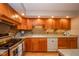 Well-lit kitchen with wooden cabinets, stainless steel appliances and ample counter space for meal prep at 2613 W Queensbury Rd, Muncie, IN 47304