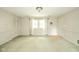 Bright living room with light walls, featuring a large window, closet, and a classic ceiling light at 2613 W Queensbury Rd, Muncie, IN 47304