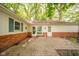 Charming brick patio with ample sunlight and views of the surrounding trees and landscaped yard at 2613 W Queensbury Rd, Muncie, IN 47304