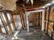 Interior shot of a dilapidated house with exposed studs, damaged walls, and debris-covered floors at 2625 E 12Th St, Indianapolis, IN 46201