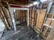 Interior shot of a dilapidated house with exposed studs, damaged walls, and debris-covered floors at 2625 E 12Th St, Indianapolis, IN 46201