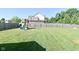 Spacious backyard with lush green grass, wooden fence, and a play set for  at 2734 Chalbury Dr, Plainfield, IN 46168