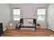 Well-lit bedroom featuring a black crib, neutral decor, wood flooring and two windows at 2734 Chalbury Dr, Plainfield, IN 46168