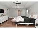 Spacious bedroom with wood floors, white furniture, tray ceiling, and modern decor at 2734 Chalbury Dr, Plainfield, IN 46168