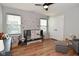 Neutrally decorated bedroom with hardwood floors, ceiling fan, black crib, and gray ottoman at 2734 Chalbury Dr, Plainfield, IN 46168