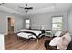 This main bedroom features wood floors, a ceiling fan and many windows for ample natural light at 2734 Chalbury Dr, Plainfield, IN 46168