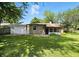 Well-maintained backyard showcasing lush lawn, a stone house exterior, and a screened-in back porch at 2811 Beech Dr, Columbus, IN 47203