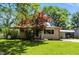 Charming single-story home with well-maintained lawn and mature trees, complemented by a convenient carport at 2811 Beech Dr, Columbus, IN 47203