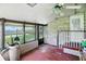 Enclosed sun room featuring brick accents, ceiling fan and access to backyard at 2811 Beech Dr, Columbus, IN 47203