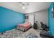 Cozy bedroom featuring a ceiling fan, stylish rug, and a soothing blue accent wall at 3341 Carica Dr, Indianapolis, IN 46203