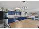 Bright kitchen has blue cabinets and stainless steel appliances, with a view to stairs and living room at 3341 Carica Dr, Indianapolis, IN 46203