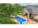 Aerial view of a backyard featuring a pool, patio, and lush landscaping at 3399 Nottinghill Blvd, Plainfield, IN 46168
