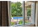 Backyard pool view from a bedroom window, surrounded by lush greenery at 3399 Nottinghill Blvd, Plainfield, IN 46168