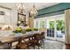 Cozy dining area with stylish lighting, a large farmhouse dining table, and access to outdoor space at 3399 Nottinghill Blvd, Plainfield, IN 46168