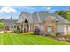 Charming home featuring brick and stone accents, a covered porch, and manicured lawn at 3399 Nottinghill Blvd, Plainfield, IN 46168