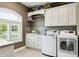 Well-organized laundry room with white cabinetry and modern washer and dryer at 3399 Nottinghill Blvd, Plainfield, IN 46168