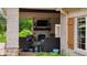 Comfortable covered outdoor living space with brick fireplace and a large TV at 3399 Nottinghill Blvd, Plainfield, IN 46168