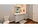Clean bathroom offering a single sink vanity with white cabinetry and contrasting dark wood flooring at 3443 Thomas Jefferson St, Westfield, IN 46074