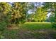 Spacious backyard featuring a wooden swing set and mature trees at 3518 Woodale Rd, Indianapolis, IN 46234
