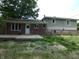 View of the backyard from the home with a deck and manicured lawn at 3518 Woodale Rd, Indianapolis, IN 46234