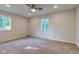 Spacious bedroom with neutral carpet, ceiling fan, and natural light from two windows at 3518 Woodale Rd, Indianapolis, IN 46234