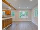 Eat-in kitchen featuring wood cabinets, granite countertops, and a view of the backyard through large windows at 3518 Woodale Rd, Indianapolis, IN 46234