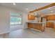 Open concept kitchen with wood cabinets, stone countertops and an open layout to the living room at 3518 Woodale Rd, Indianapolis, IN 46234