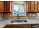 The kitchen features a double sink, granite countertops, and wooden cabinets at 3518 Woodale Rd, Indianapolis, IN 46234